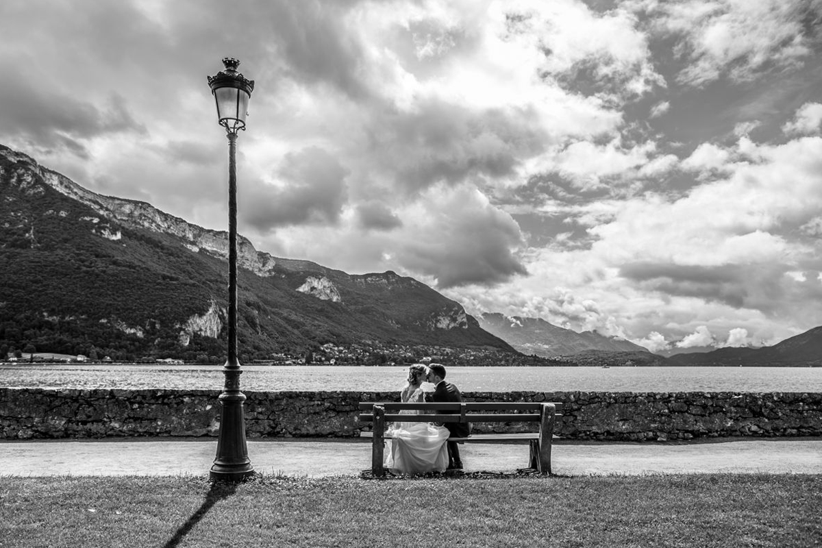 Paysage en noir et blanc avec des marié sur un banc.